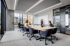 people are sitting around a conference table in an office