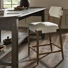 a wooden table with two chairs and a vase sitting on top of it next to a window