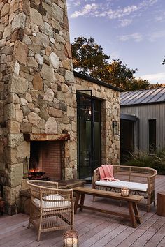 an outdoor fireplace and patio furniture on a wooden deck