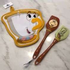 two children's utensils sitting on top of a marble counter next to each other