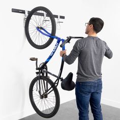 a man is lifting a bicycle on a wall