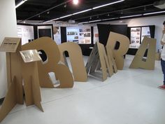 a woman standing in front of large letters that spell out the word brob on display