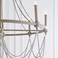 a chandelier with beads hanging from it's arms and two candles in the middle