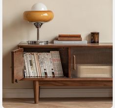 a book shelf with books and a lamp on top