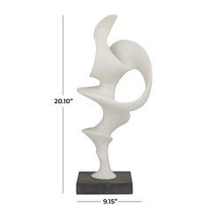 a white sculpture sitting on top of a black base next to a measuring ruler with the measurements