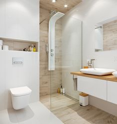 a bathroom with two sinks, a toilet and a stand up shower in the corner