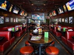 the inside of a sports bar with red booths