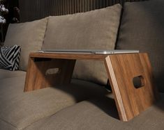 a laptop computer sitting on top of a wooden table in front of a brown couch