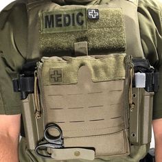 the back of a man wearing a medical vest with scissors in his pockets and clippings