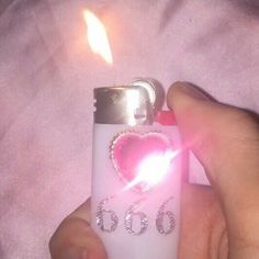 someone is holding a lighter with a heart on it