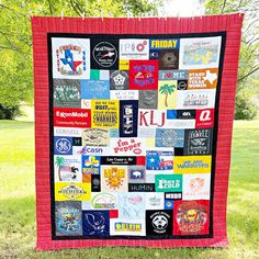 a quilt made out of t - shirts is on the grass in front of some trees