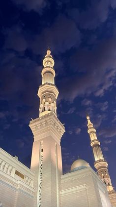 a tall white building with two towers at night