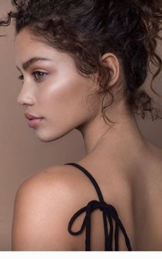 a woman with curly hair wearing a black dress