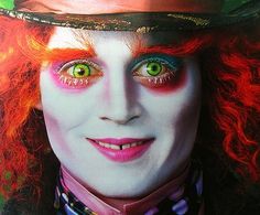 a close up of a person with red hair and green eyes wearing a top hat