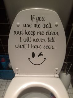 a white toilet with a smile drawn on the lid and some words written in black