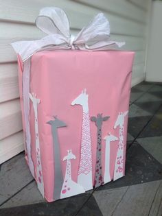 a present wrapped in pink paper with giraffes on it