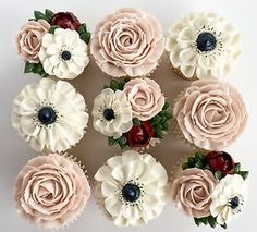 twelve cupcakes decorated with pink, white and red frosting flowers on top of each other