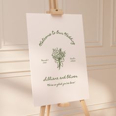 an easel with a sign on it that says welcome to our wedding and flowers