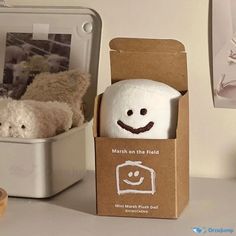 two stuffed animals sitting in a box on a table next to a photo and other items