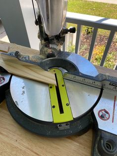 a machine that is cutting wood with a ruler