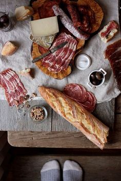 an assortment of meats and cheeses on a table