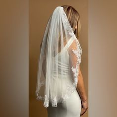 a woman wearing a wedding veil with lace on it