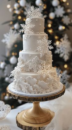 a white wedding cake sitting on top of a wooden stand next to a christmas tree