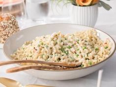 a white bowl filled with macaroni and peas