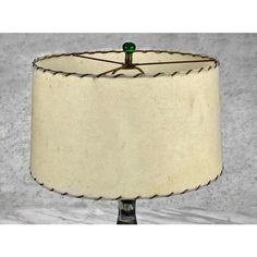 a white lamp with a green light on it's side and a black cord