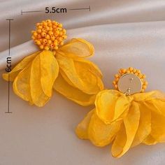 two yellow flowers are attached to some fabric