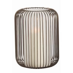 a white candle sitting inside of a metal caged container on top of a table