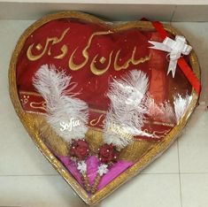 a heart shaped box with feathers on it