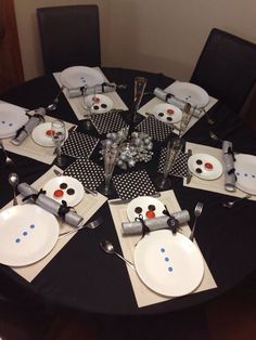 the table is set with christmas decorations and place settings