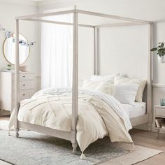 a white bed sitting in a bedroom next to a dresser with drawers and a mirror