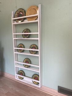 a white shelf with plates on it in a room