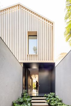 an entry way to a house with stairs leading up to the door and plants growing on the side