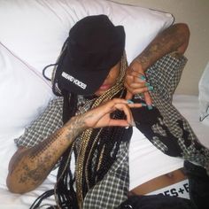 a person laying on top of a bed covered in lots of tattoos and piercings