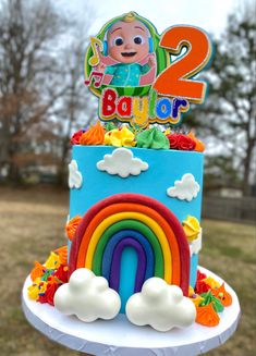 a birthday cake with a rainbow and the number 2 on top is for two year old