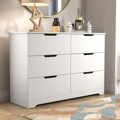 a white dresser with drawers and a mirror