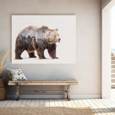 a large brown bear standing on top of a snow covered ground next to a wooden bench