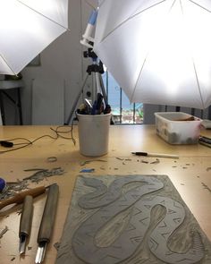 a table topped with lots of crafting supplies on top of a wooden table covered in white umbrellas