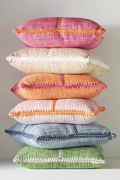 five pillows stacked on top of each other in different colors and sizes, all with the same pattern