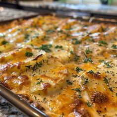 a casserole dish with cheese and herbs on top, ready to be eaten