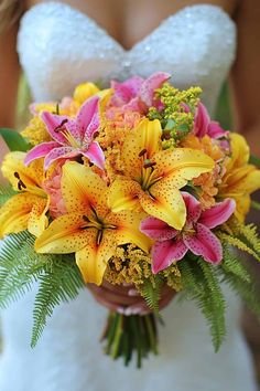 a bride holding a bouquet of yellow and pink flowers