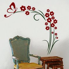 a chair sitting next to a small table with a butterfly on the wall behind it