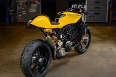 a yellow and black motorcycle parked in a garage