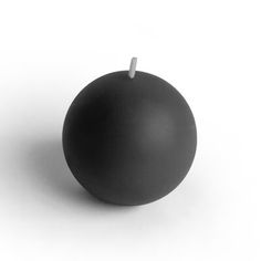 a black candle sitting on top of a white table