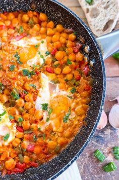 a skillet filled with chickpeas and eggs