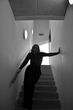 a woman is standing on the stairs with her arms outstretched