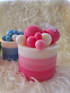 two small containers with candy and candies in them on a white furnishing